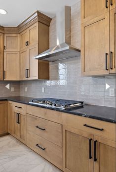 an empty kitchen with wooden cabinets and black counter tops in the middle of the room