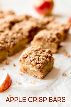 an apple pie is cut into pieces on a piece of paper next to some apples