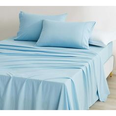 a bed with blue sheets and pillows on it