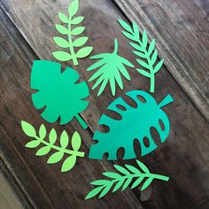 cut out paper leaves sitting on top of a wooden table