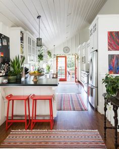 a kitchen with two stools in front of the counter and an area rug on the floor