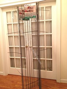 a tall metal tower sitting in front of a window on top of a hard wood floor