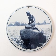 A unique ceramic wall plate from Denmark made by Royal Copenhagen pottery, featuring a lone mermaid resting on a rock watching humans building their city.  In excellent condition with no cracks or damage All items are pre-loved so may show signs of previous use  All items are posted in recycled packaging Unique Ceramics, Royal Copenhagen, Wall Plate, A Rock, Recycled Packaging, Plates On Wall, Halloween Shopping, Denmark, Mermaid