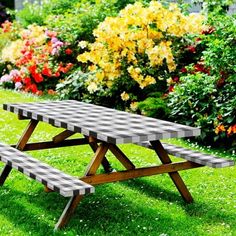 a picnic table sitting in the grass near flowers