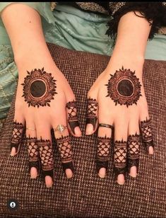 two hands with henna tattoos on them