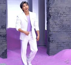 a male in a white suit and purple shirt