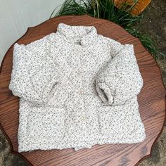 Stay warm and stylish this winter with our Floral Fleece-Lined Cotton-Padded Jacket! 🌸🧥 Crafted from cozy cotton, this jacket is designed to keep your little one snug in chilly temperatures. The turn-down collar adds a touch of elegance, while the single-breasted closure ensures easy on and off. With its adorable floral print and functional pockets, this outerwear is perfect for girls aged 18 months to 8 years. Embrace the cold season with confidence and comfort in this trendy jacket. ❄️✨ Spec Cotton Puffer Jacket With Fleece Lining, Hooded Cotton Puffer Jacket For Cold Weather, Cotton Long Sleeve Puffer Jacket For Cold Weather, Long Sleeve Cotton Puffer Jacket For Cold Weather, Cozy Winter Puffer Jacket With Pockets, Cozy Puffer Jacket With Pockets For Winter, Quilted Beige Cotton Outerwear, Hooded Cotton Puffer Jacket With Padded Collar, Beige Cotton Outerwear With Fleece Lining