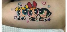 the powerpuff girls tattoo on the back of someone's arm is shown