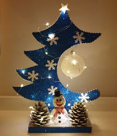 a lighted christmas tree with snowman and pine cones