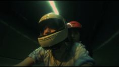 two people wearing helmets in a dark room