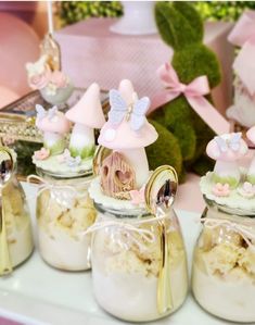 there are many small jars with little fairy decorations in them on the table next to each other