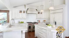 a large kitchen with white cabinets and marble counter tops, an island in the middle