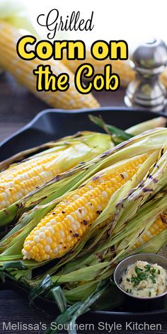 grilled corn on the cob with butter and parsley in a black plate