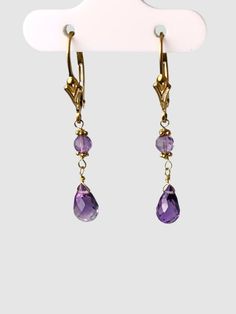 Amethyst 2 stone drop earrings. Earrings contain a pair of 5x9mm faceted amethyst briolettes with a pair of 3.2mm faceted beads on 14k yellow gold lever backs. Earrings are 1.3" long. Metal - 14k Yellow Gold Gemstones - Amethyst, Blue Topaz Length - 1.3" Amethyst Earrings Gold, Stone Drop Earrings, Amethyst Jewelry, Green Quartz, Lemon Quartz, Amethyst Earrings, Smokey Quartz, Faceted Bead, Earrings Gold