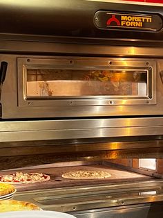 two pizzas are being cooked in an industrial oven