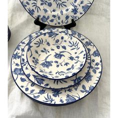 three blue and white plates stacked on top of each other with flowers in the middle