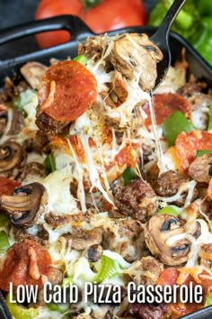 a pizza casserole with mushrooms, peppers and cheese being lifted from the casserole