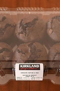 chocolate muffins in a plastic container on display