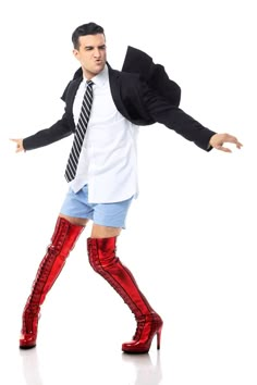 a man in short shorts and knee high boots is posing for the camera with his arms outstretched