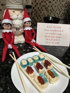 two elfs are sitting on a counter with marshmallows and jelly pops