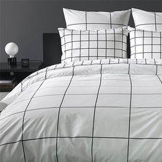 a bed with white and black checkered comforter set on it's side