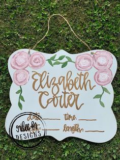 a white sign with pink flowers on it that says elizabeth coler date time weight length