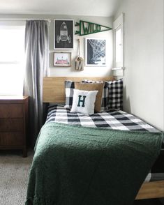 a bed room with a neatly made bed and some pictures on the wall above it