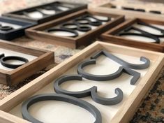 four wooden trays with black and white designs sitting on top of a carpeted floor