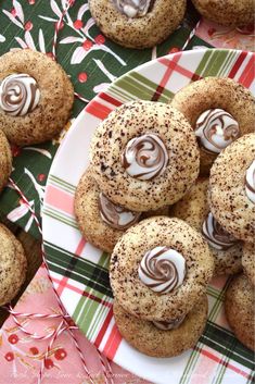 cookies with chocolate frosting and sprinkles are on a plate next to christmas decorations