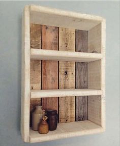 a shelf made out of wooden planks with jars on the bottom and two shelves below