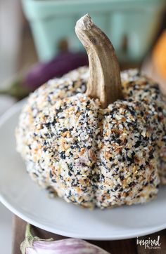 a white plate topped with a small pumpkin covered in seeds and sprinkles