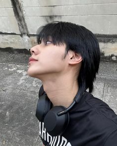 a young man with black hair wearing headphones