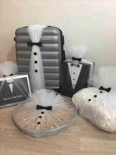 the tuxedo suit and bow tie are on display in front of suitcases