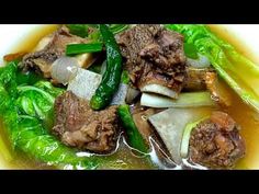 a bowl filled with meat and vegetables covered in broth