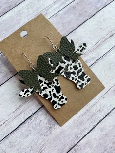 These cow earrings are super cute! Made with stainless steel earring findings and faux leather (single-sided). Each pair of earrings will be slightly different because of the variability in the faux leather pattern.  2.125 inches long by 1.75 inches wide. Free shipping on orders $35 and over! Warning: Choking Hazard. Small Parts. Keep out of reach of children under 5 years old. Wood Cow Tag Earrings, Cow Print Faux Leather Earrings, Cow Head Earrings, Leather Cow Keychain, Cow Tag Earrings, Faux Leather Earring, Cow Earrings, Cow Head, Leather Ideas