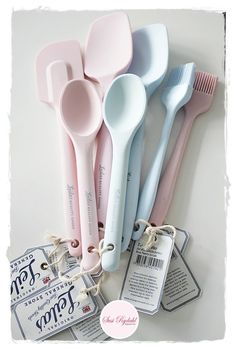 five pink and blue toothbrushes sitting next to each other on a white surface