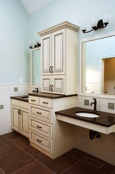 a bathroom with two sinks and cabinets in it