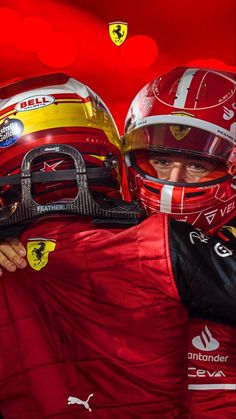 two men in red racing suits and helmets holding each other's shoulders with the words ferrari on them