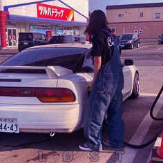 a man filling up his car at a gas station