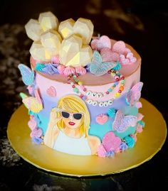 a colorful cake decorated with butterflies and a woman's face