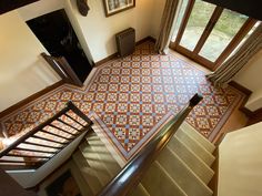 an aerial view of a stair case in a house with tiled floors and wooden doors