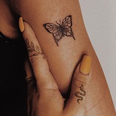 a woman's arm with a butterfly tattoo on her left wrist and the word love written in cursive writing