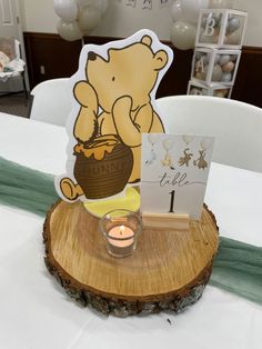 a wooden table topped with a candle and a bear cut out on top of it