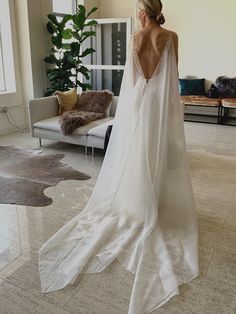 the back of a woman's wedding dress in a living room with couches