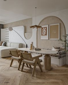 a living room and dining area with wood flooring, white furniture and artwork on the walls