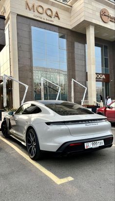 a silver sports car parked in front of a building