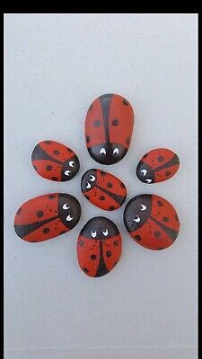 six red ladybugs painted on rocks with black dots