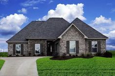 a brick house sitting on top of a lush green field