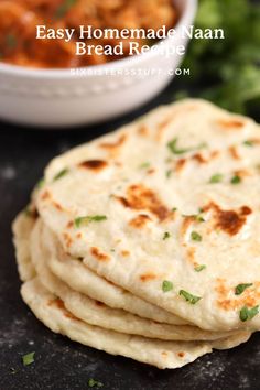 several flat breads stacked on top of each other next to a bowl of chickpeas