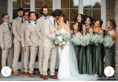 a group of people standing next to each other in front of a building with flowers